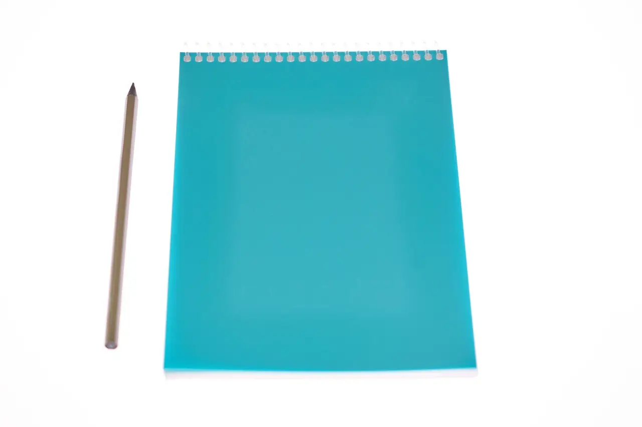 A spiral notepad with a pencil on a desk